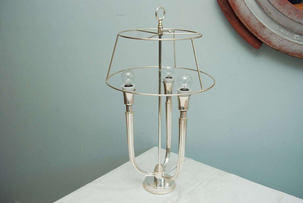 Art Deco style silverplate bouillotte lamp in the manner of Emiles-Jacques Ruhlmann.<br />
The open shade over three branches issuing from a beaded base.