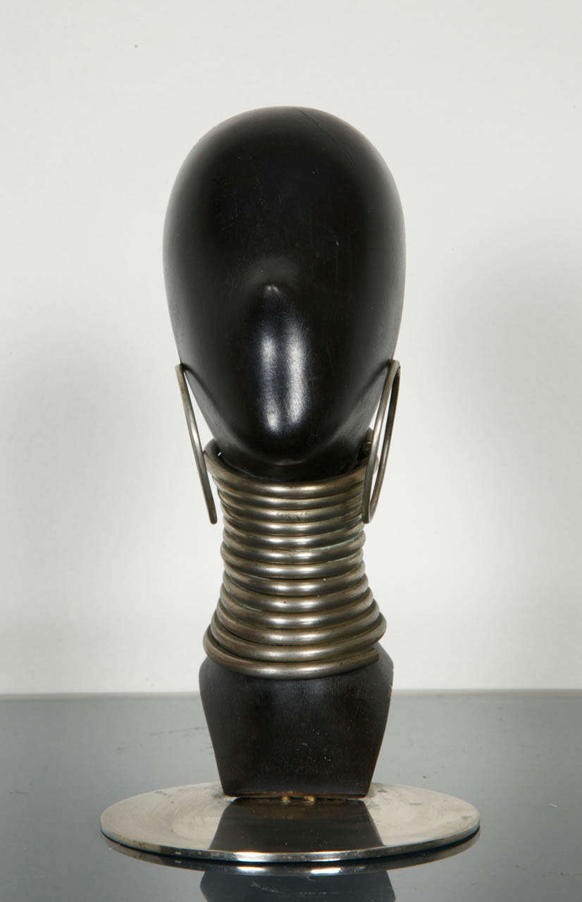 Sculpture de Karl Haguenauer représentant une tête de femme africaine avec anneau de cou et boucles d'oreilles créoles en acier nickelé sur une base nickelée. Vers 1930:: Tampon sous la base wHw Atelier Haguenauer Wien. 

Hauteur : 6.69