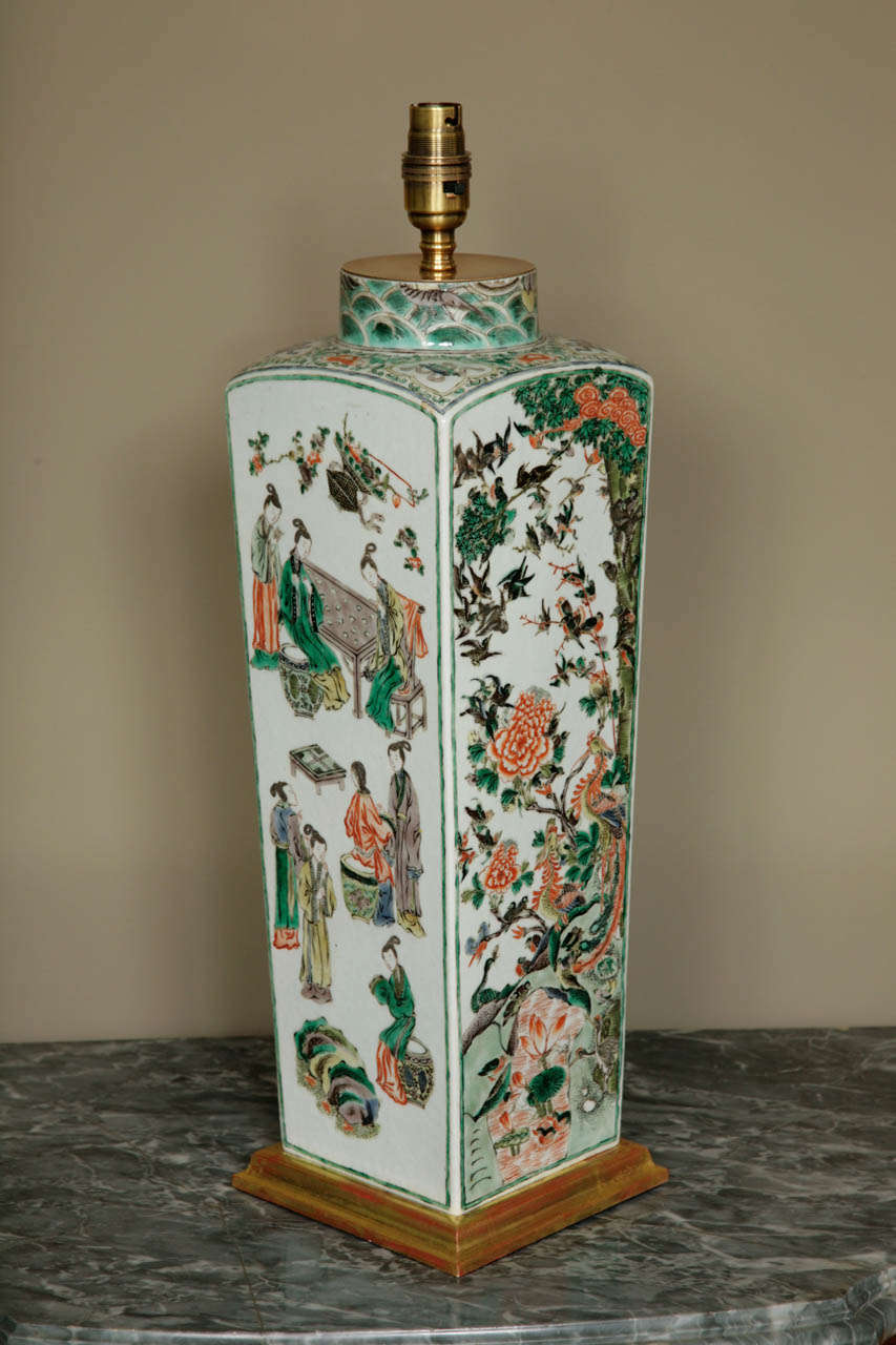 A tall Famille Verte square vase, Late 18th century of tapering form, enameled on each side with dramatic scenes: mountainous landscape with deer, another side with figures in conversation, another landscape with phoenixes, peonies and birds and