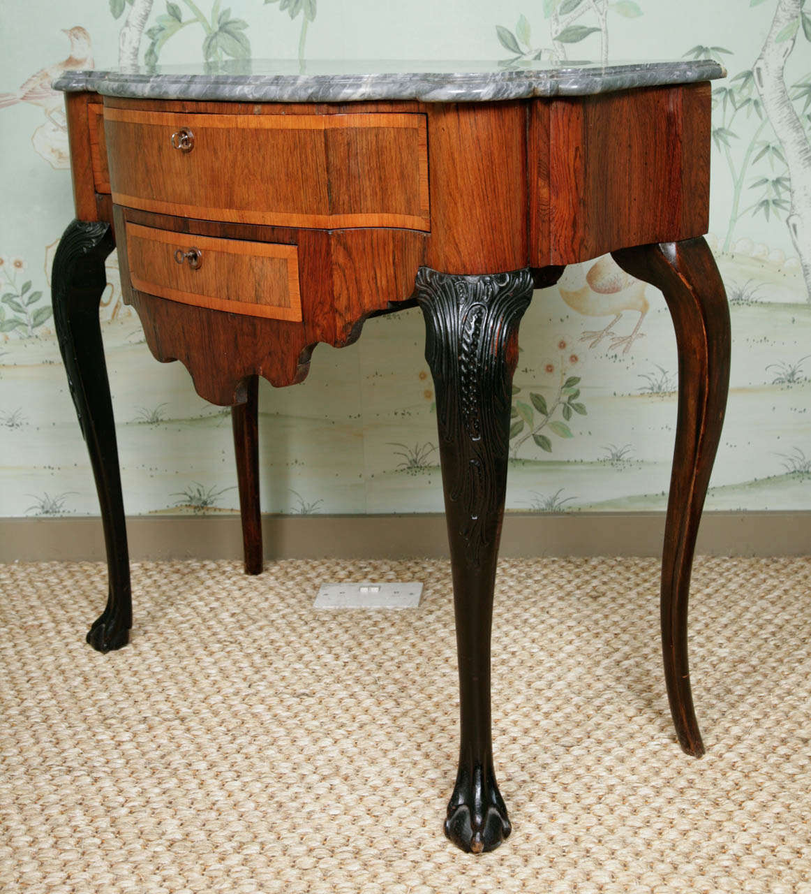 A Dutch 18th century side table, the shaped top with soft grey St. Anne Marble. Veneered in kingwood and walnut with a long drawer and smaller drawer below, raised on slender carved cabriole legs ending in ball and claw feet, circa 1740.
