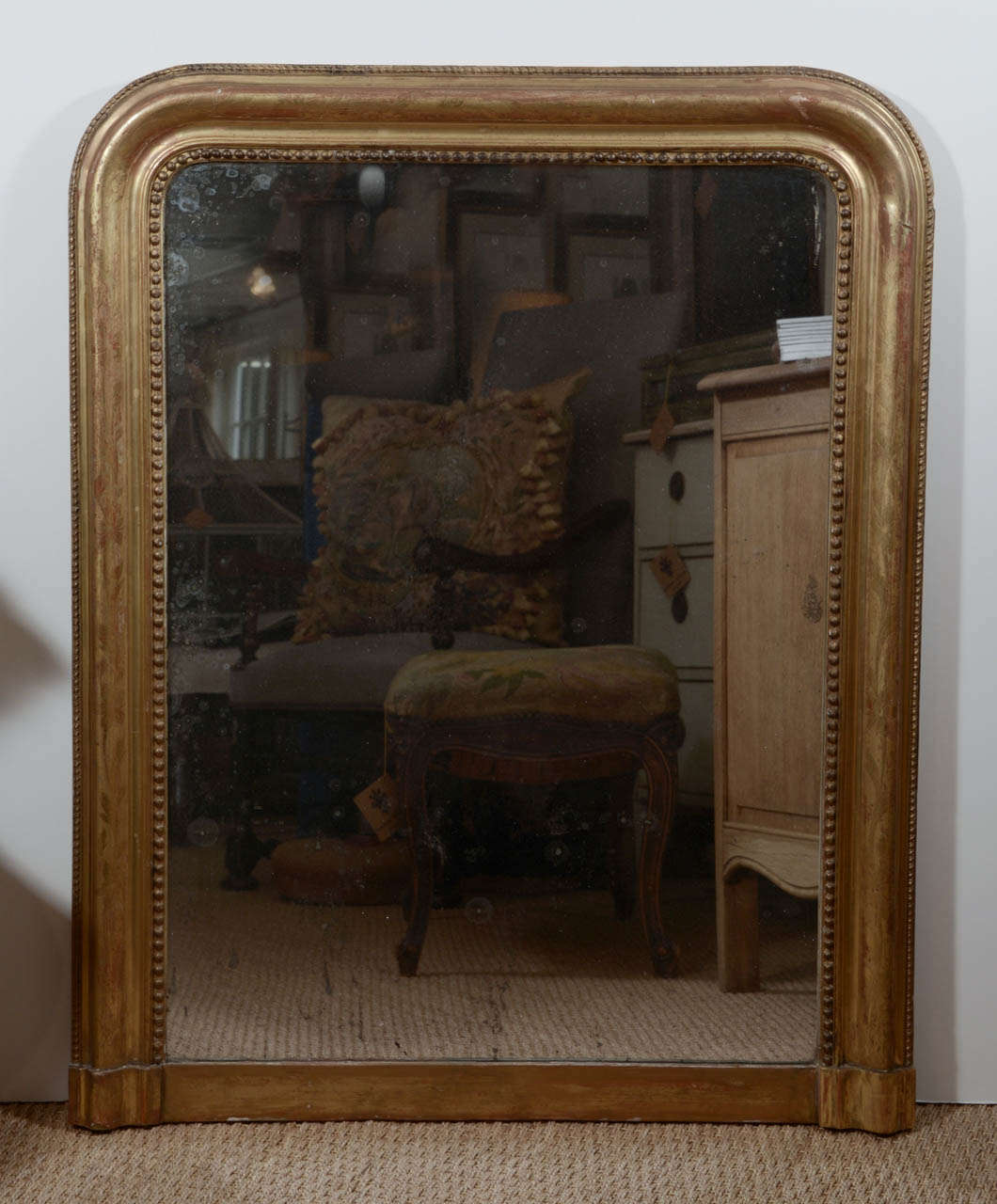 This lovely 19th century Louis Phillip mirror is sure to brighten any space. Use it in a bedroom, bathroom or dining room to add a touch of old world glamor. The carved wood frame has patinated gilding, 
