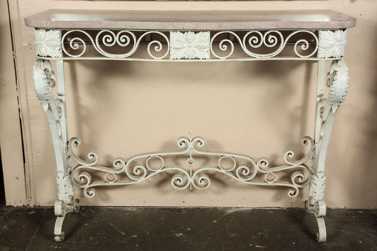 1980s white cast iron console table with a pink marble top in a floral design. The cast and wrought iron base has a feather and floral design. This can be seen at our 1800 South Grand Ave location in Downtown Los Angeles.