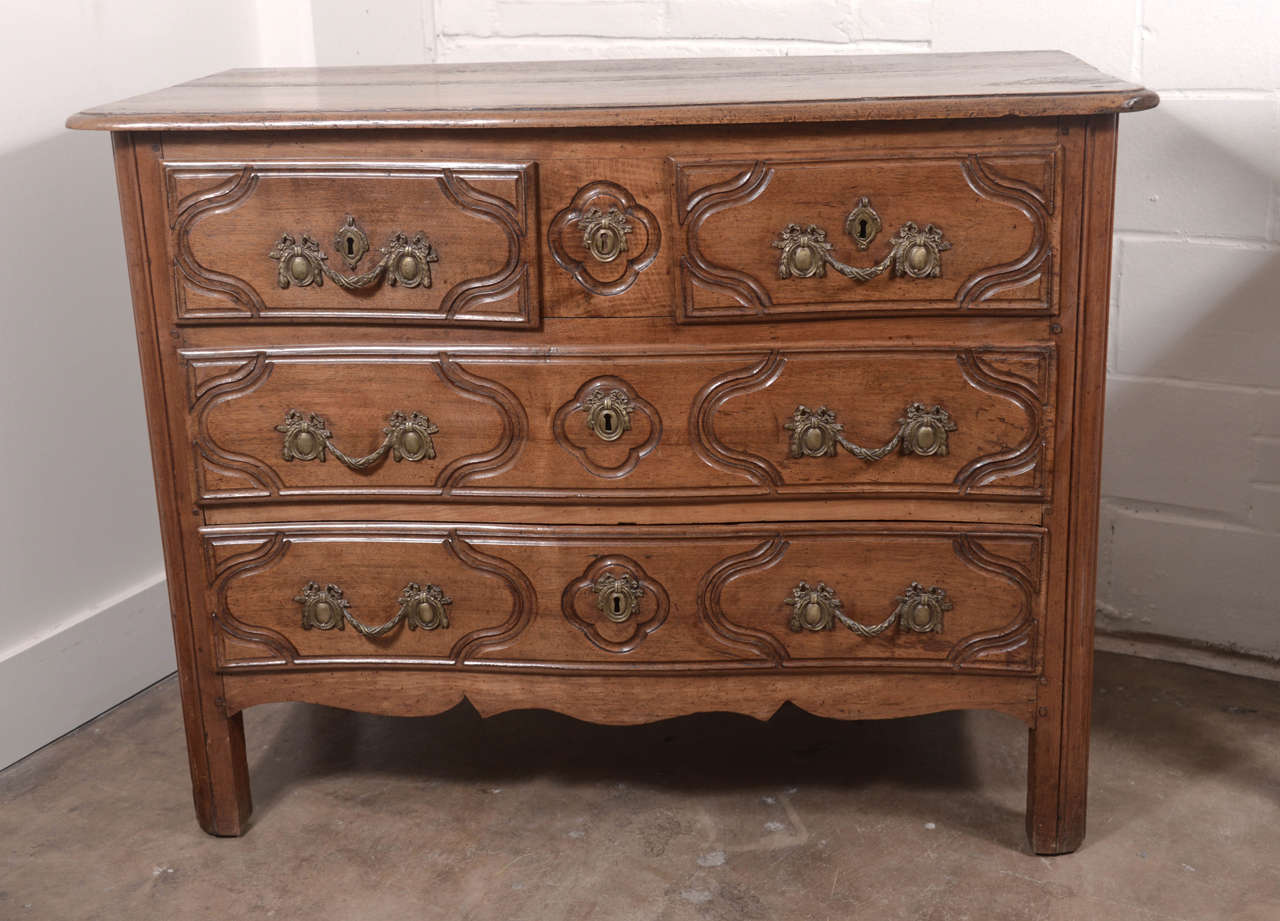 18th century four-drawer Louis XV walnut commode. Original bronze hardware and beautiful carving throughout. Top has a slight 