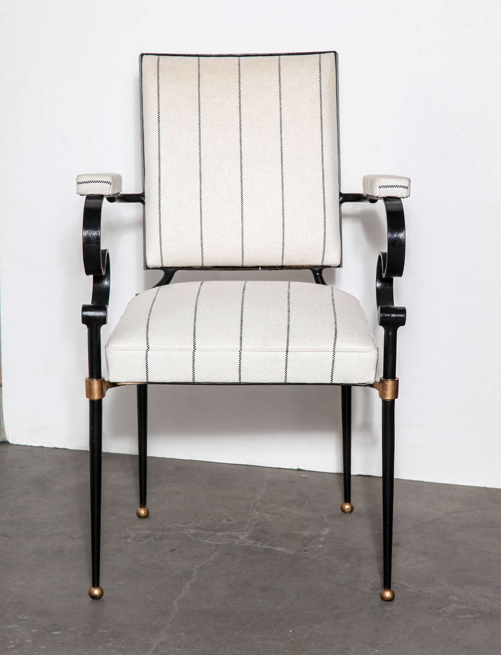 A pair of impeccable French 20th Century iron and gilt armchairs in the manner of Gilbert Poillerat. Upholstered in black and white striped linen by Holland & Sherry.