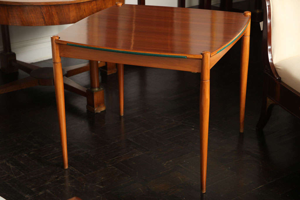 Early 20th century beechwood games table, green felt top, reverses to polished wood top, round tapered legs.