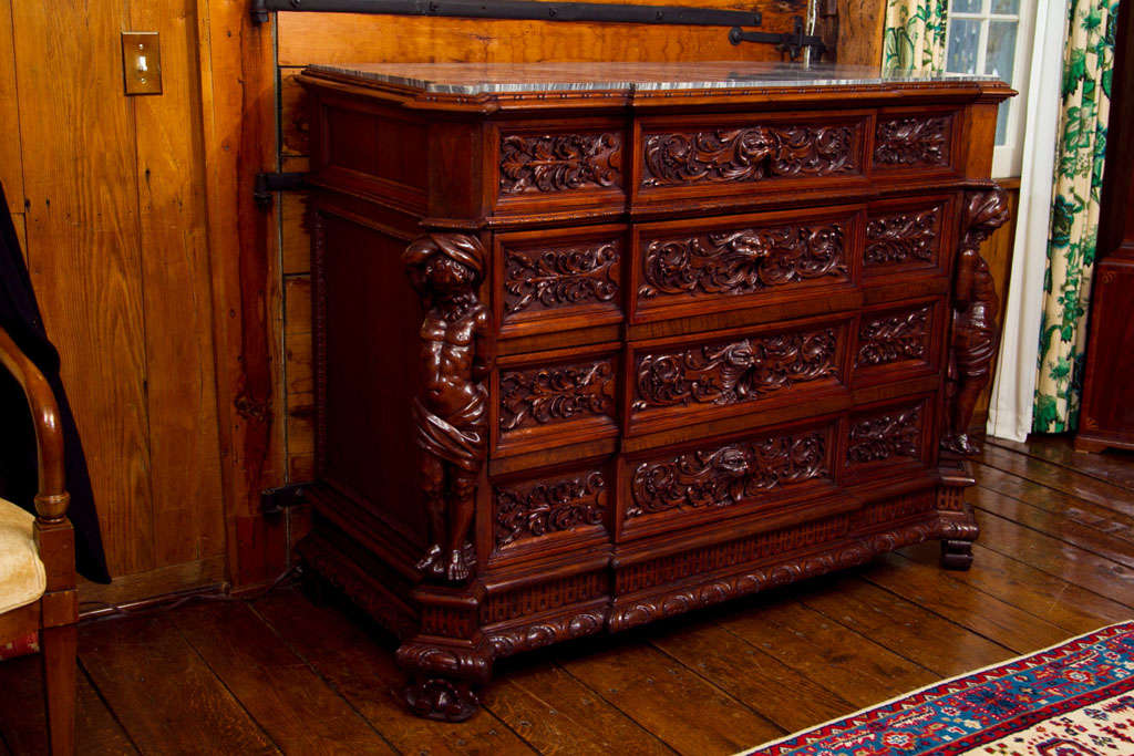 This highly carved and detailed Italian commode in the Renaissance style features some of the most exquisite carving we have seen in some time. Each figure is individually carved with opposing arms raised, and each of the four drawers features a