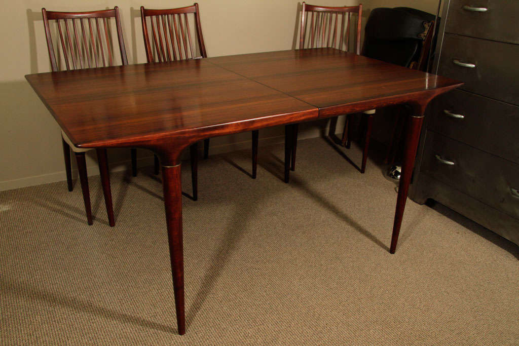 Mid century modern rosewood dining room suite. The solid rosewood table has two leaves and comes with six slat back side chairs with upholstered seats.<br />
<br />
Reduced From: $8,600<br />
<br />
Dimension:<br />
Table: 59