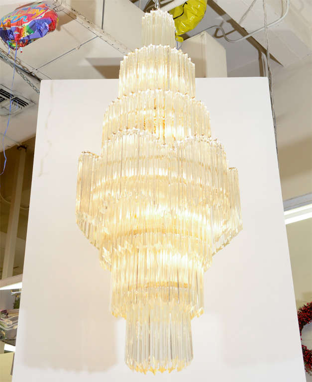 A large vintage clear Murano glass chandelier by Camer composed of four pointed prisms suspended from a brass frame. Extra rods available. The piece is in good vintage condition with age appropriate wear; some small chips to glass rods.