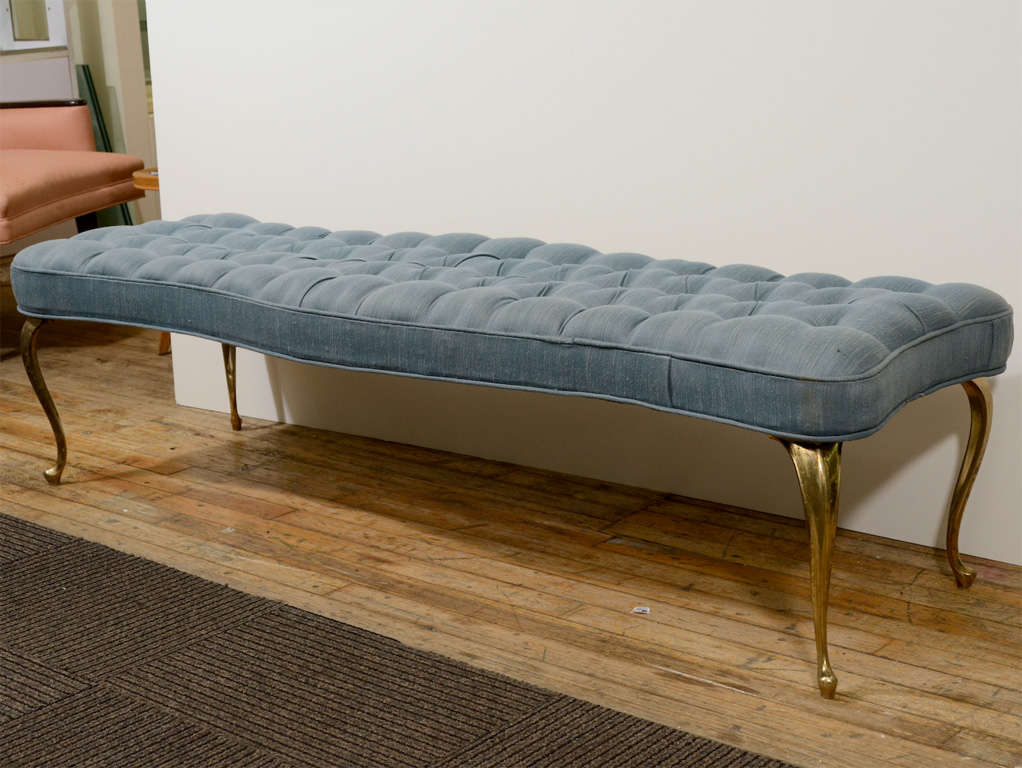 A vintage bench with pale blue original pleat-tufted upholstery and solid brass cabriole legs. The piece has age appropriate wear; fading and spotting to upholstery