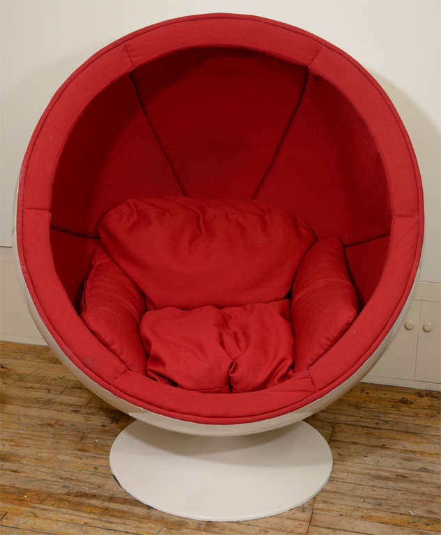 A vintage ball form swivel chair by Eero Aarnio. The chair consists of a white fiberglass shell with original red interior cushions. The Ball chair was originally designed in 1963 and has since become an icon of mid century space age design. The