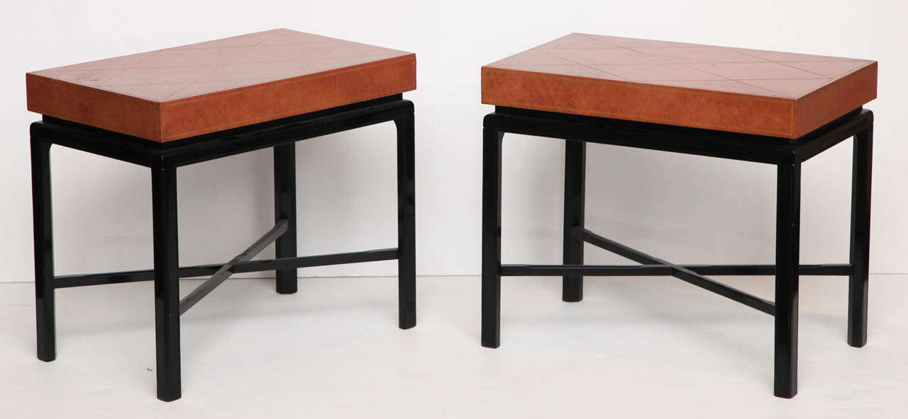 Pair of ebonized wood side tables by Tommi Parzinger with original leather tops with gold tooling.