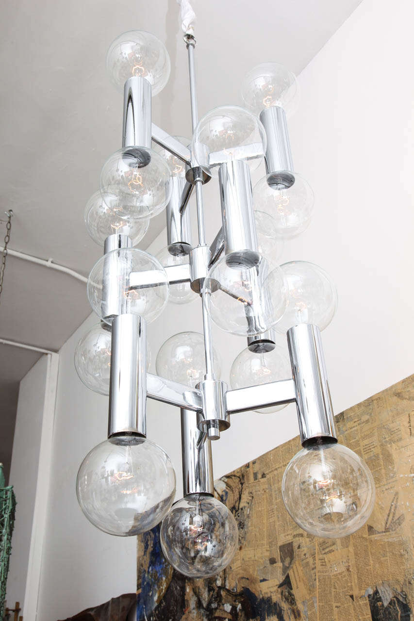 A circa 1960s futurist form ceiling fixture, crafted of polished chrome, with nine arms each supporting a two-light tubular socket cover.