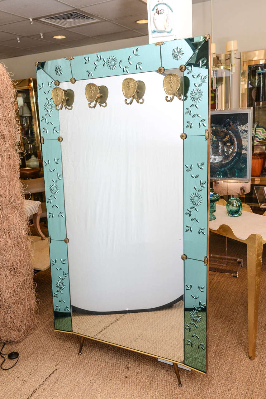 This is beyond amazing, this large leaning wall mirror has brass legs and ornate hooks for hanging scarves, hats or whatever you like. The aqua blue/green carved panels are also decorated with beautiful accents.  Made in Italy by Cristal Art.