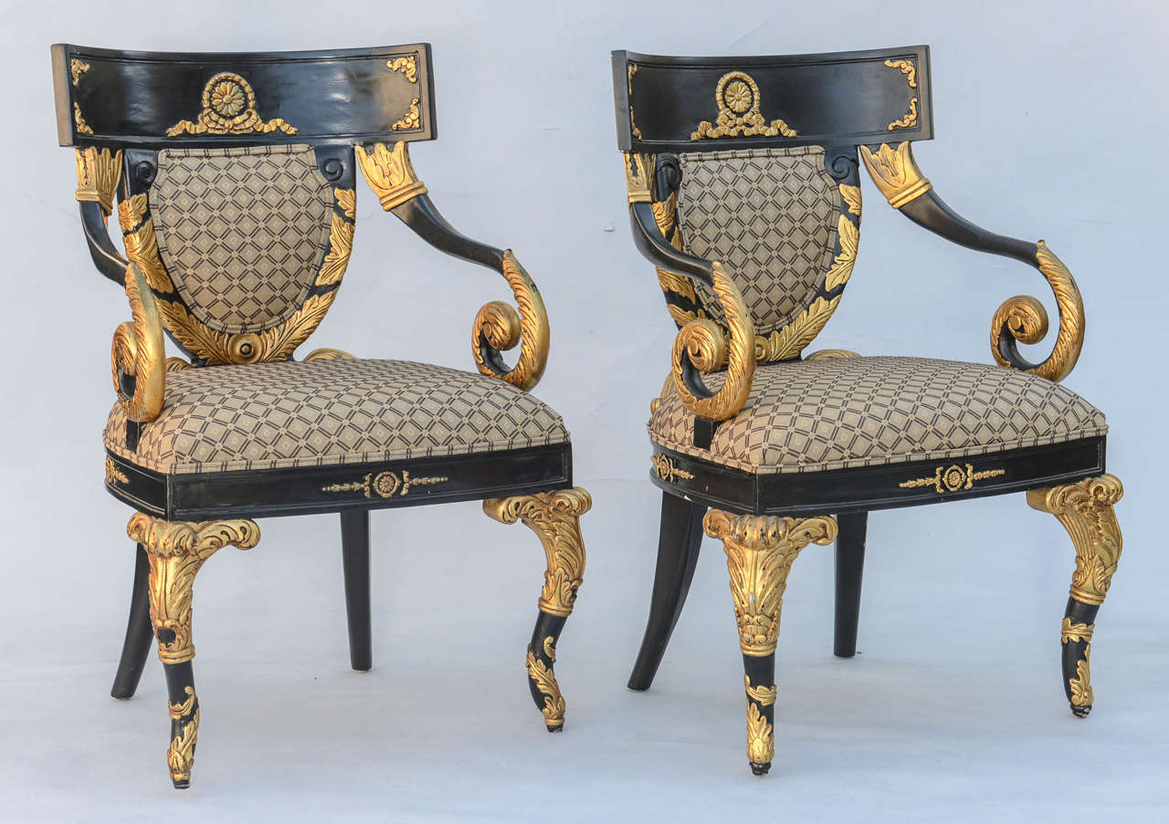 Pair of armchairs, each having a lacquered finish with parcel gilt; bowed crestrail centered with rosette and ribbons over padded backrest, flanked by exaggerated scrolling arms, stuff-over seat raised on fielded rail, raised on 