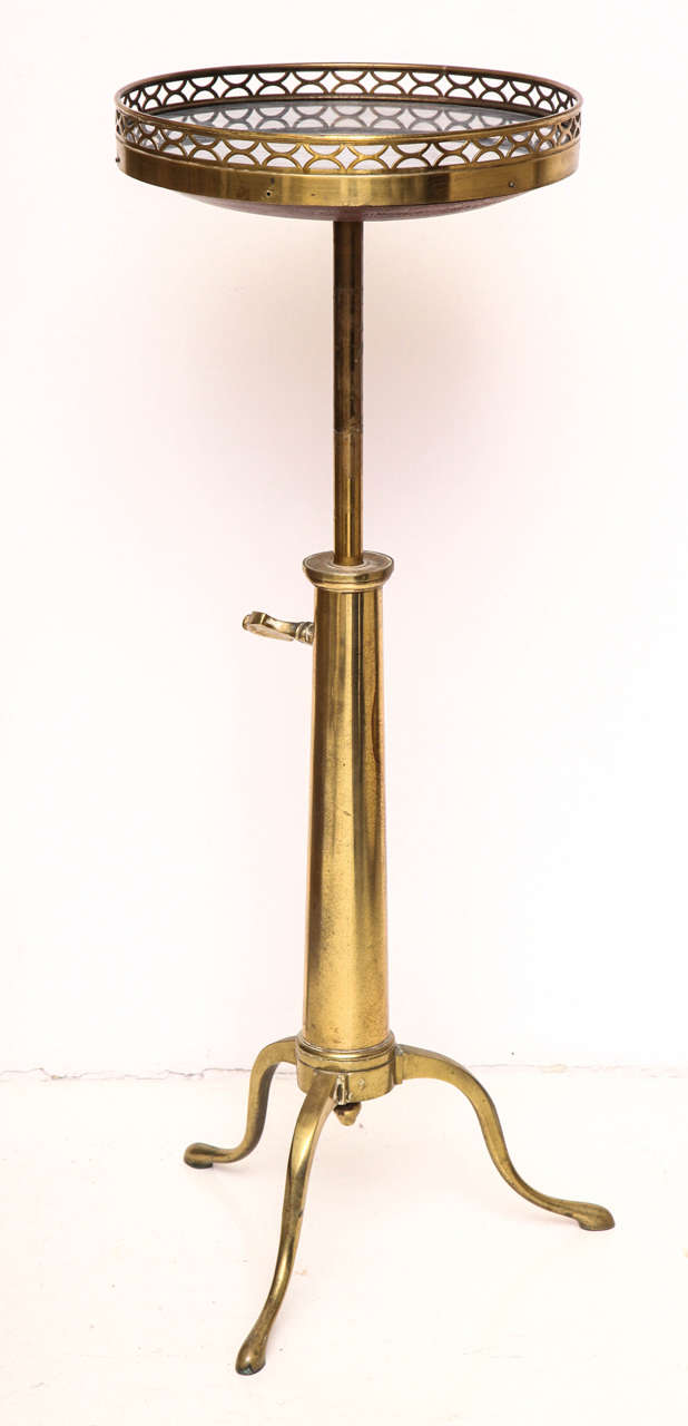 Brass occasional table with a circular pierced gallery top with inset grey-veined white marble on an adjustable shaft with cabriole legs and pad feet, 
French, circa 1970.