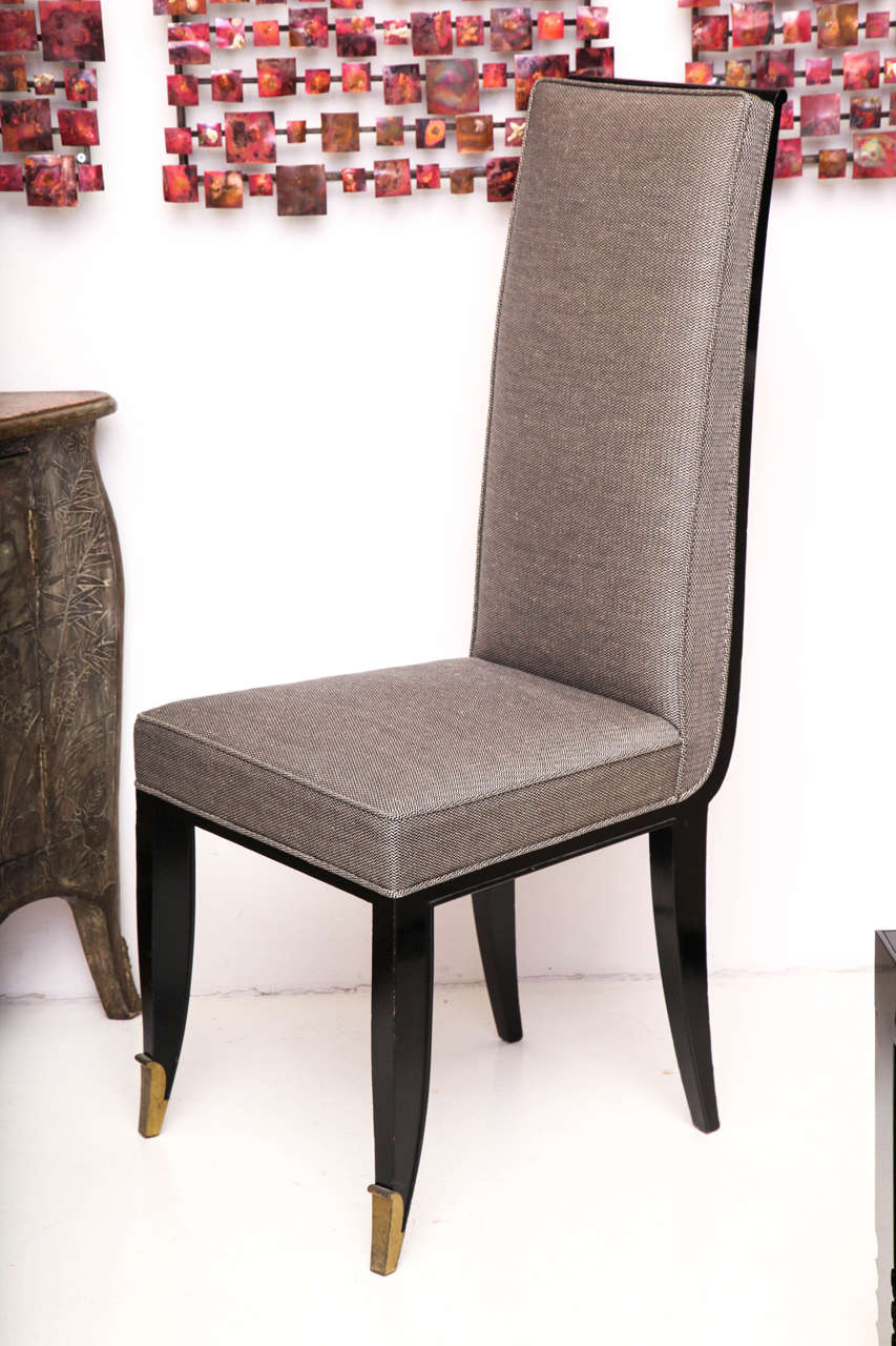 Jean Pascaud (1903-1996)
Set of four side chairs with black lacquered finish and upholstered seats and backs. Raised on gently curved saber legs. Front legs have gilt bronze sabots. Upholstered in grey linen.
French, circa