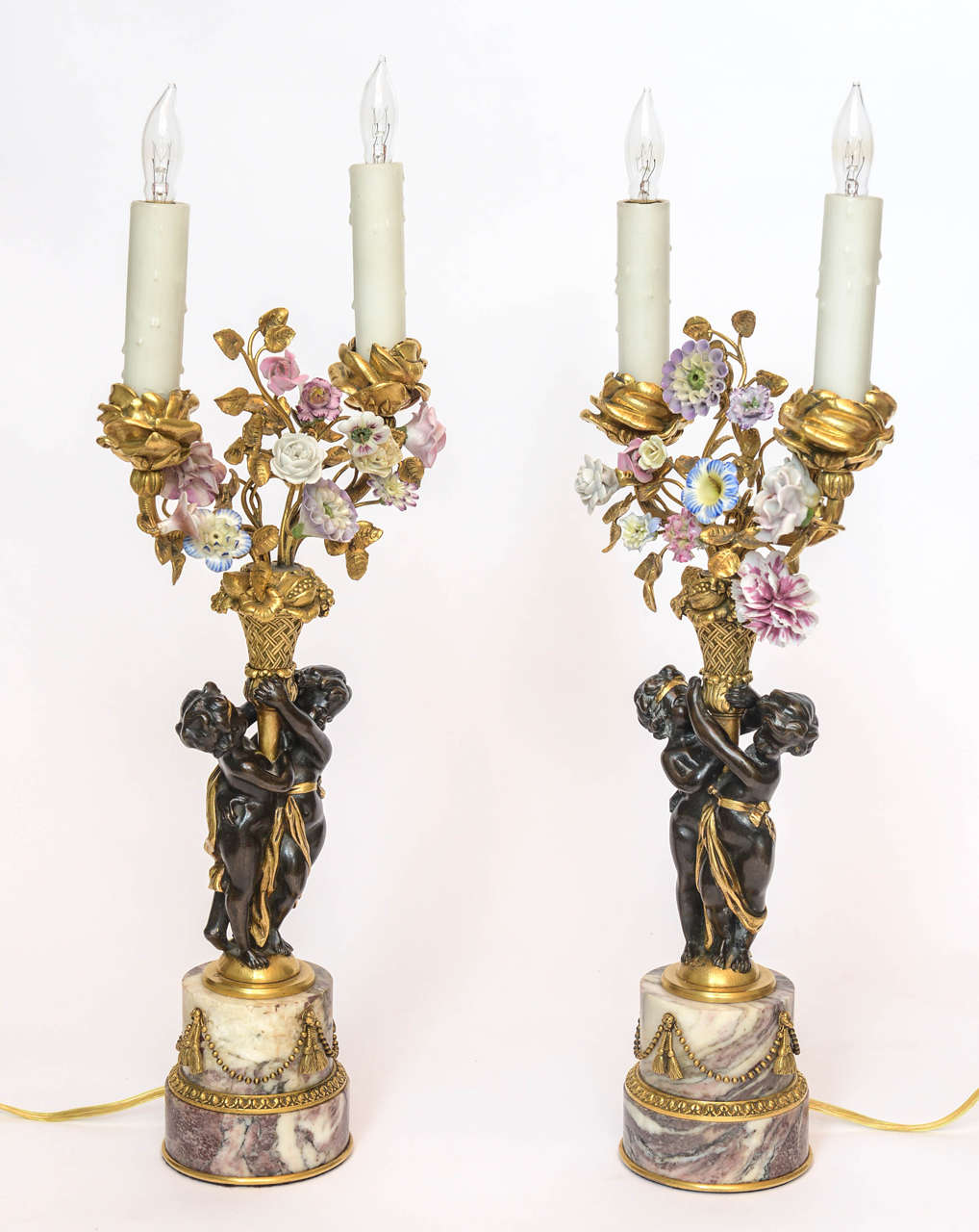 A pair of candelabra mounted on rouge marble with two children holding a flower basket and flowers, by E.F. Caldwell, circa 1900. Height - 16