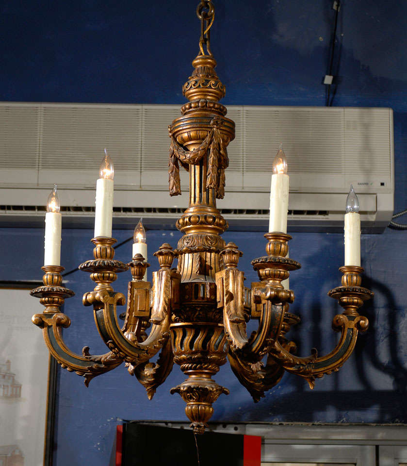 This wood chandelier sports 6 large candles and has been restored
with the original green painted panels behind gilt. The measurements do not include the canopy and chain, which can be altered in height if required.
