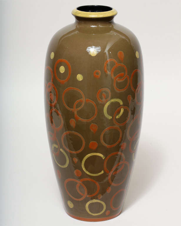 Large ovoid glazed ceramic vase with flared neck with yellow painted enamel rim and with burnt orange and yellow painted enamel circles and dots on the body with burnt orange painted enamel ring on bottom.
Signed: 834 FJ Hollande 

(Price shown is