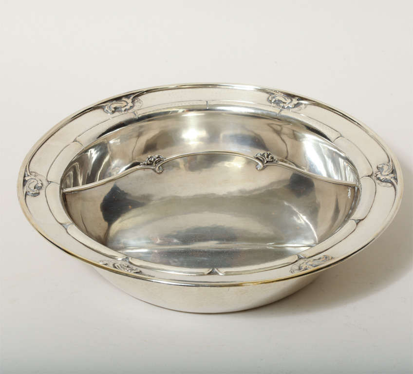 Two-compartment sterling silver vegetable dish with stylized blossom border and with an arched division applied with berries.
Engraved underneath ''JANE KANE FOULKE DUPONT / ELUTHERE PAUL DUPONT 1910-1935.''
Hallmark: Georg Jensen mark for