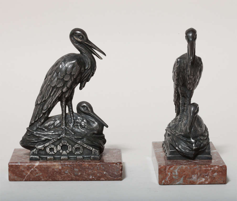 Each with silver plated stork figures mounted on a red marble base.