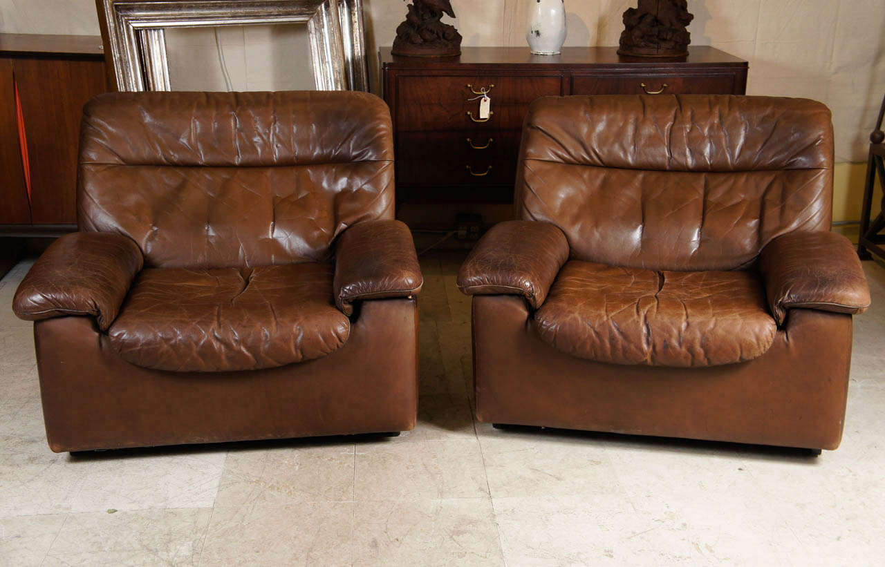 Pair of 1970s, leather club chairs by De Sede of Switzerland. There are actually two pairs and an ottoman available. Would be a great set for a media or conference room, see attached photo.