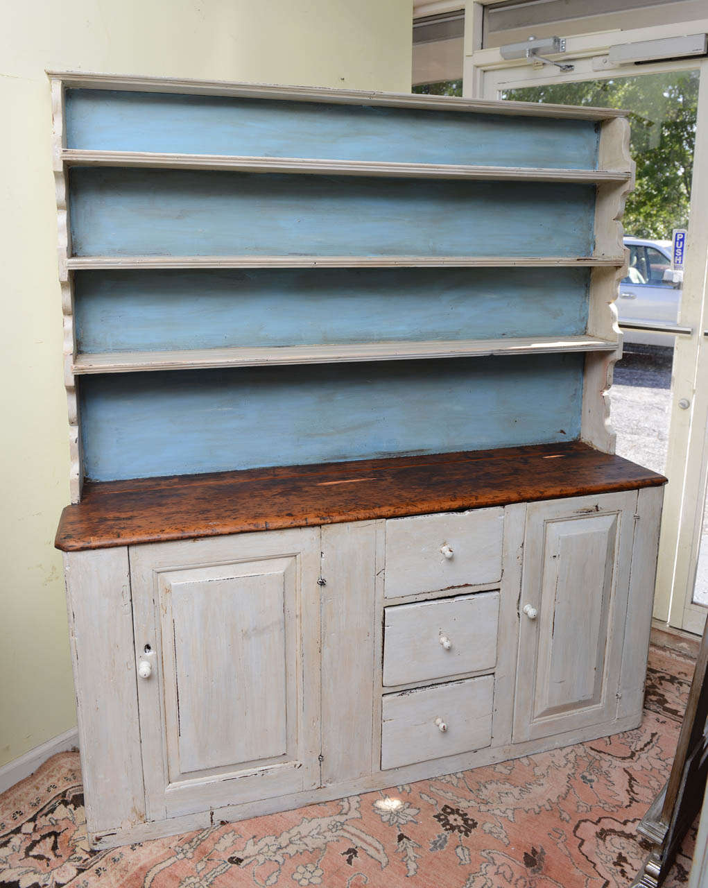 This is a very nice primitive solid pine welsh dresser some times called a pewter cupboard.  It has the original paint work maybe the blue in the back at a later time could have been added.  The drawer linings are solid wood with a little wear, I