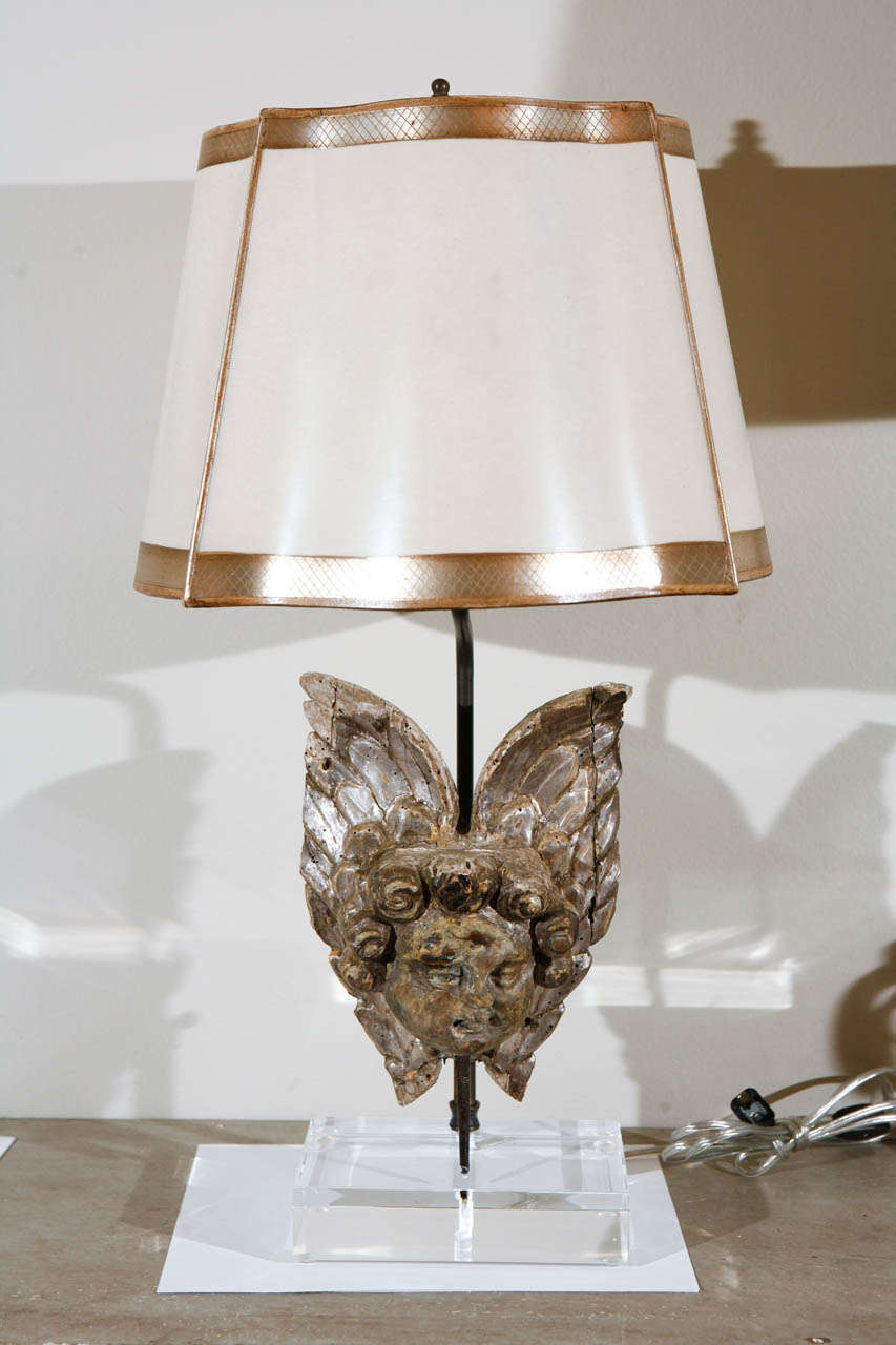 A pair of carved wood Italian cherub and wing fragments that have been turned into lamps. The lamps are fitted with a custom acrylic base. The lamps include custom Dagmar shades. Newly wired and in working order.

IT.13-003