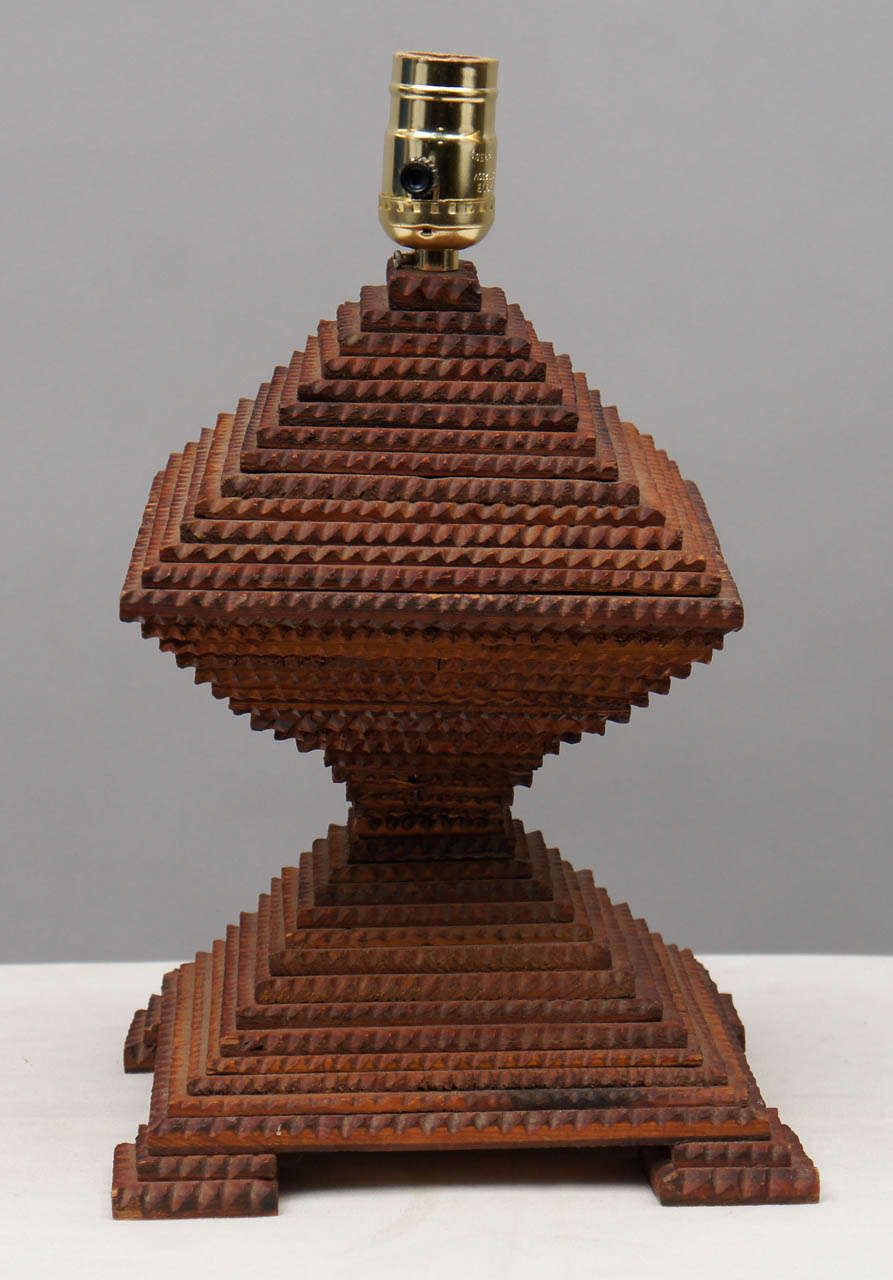 Wooden tramp-art table lamp hand carved in a double ziggurat configuration. Chip carved with an aged mahogany finish. Newly rewired.