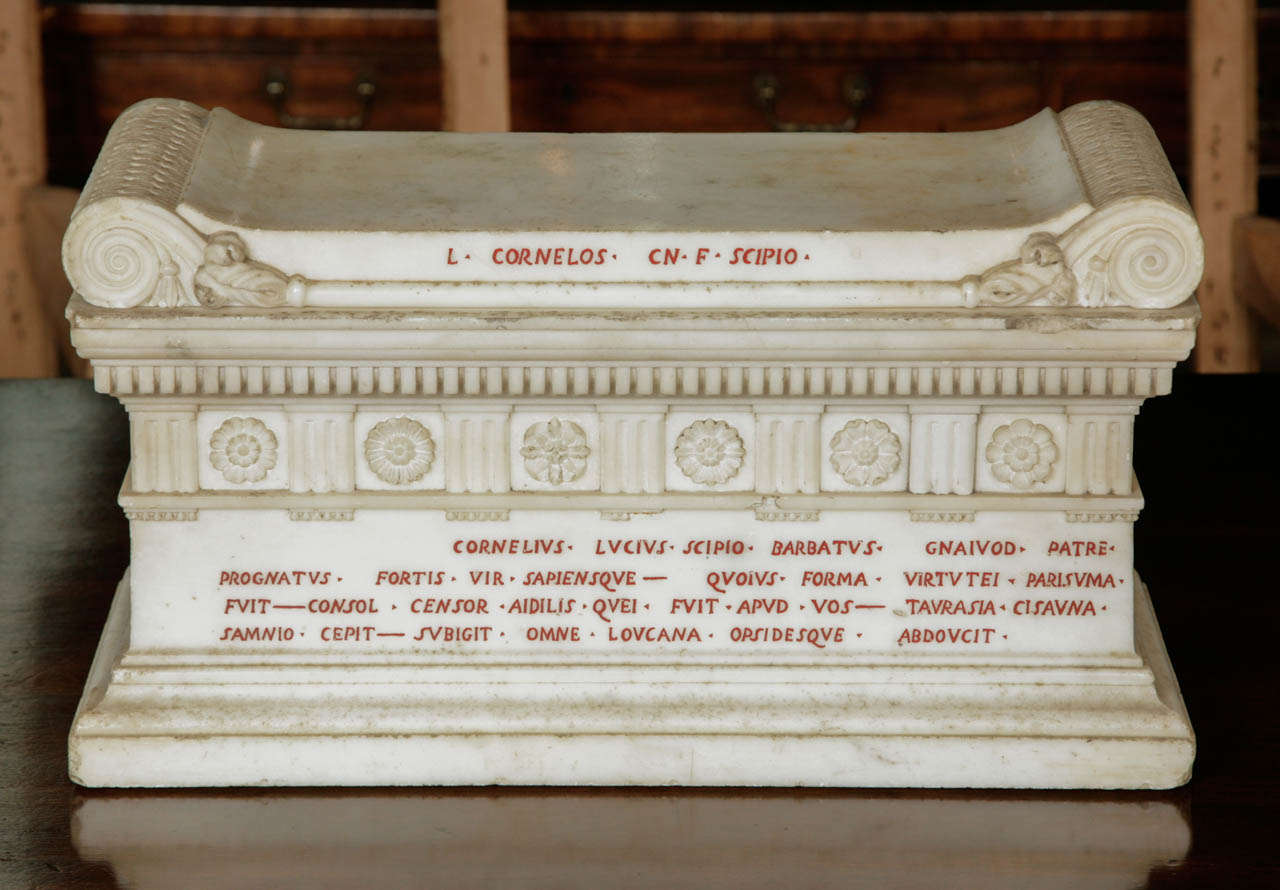 In carved statuary marble, the frieze decorated with triglyphs and rosettes, with red painted inlay lettering