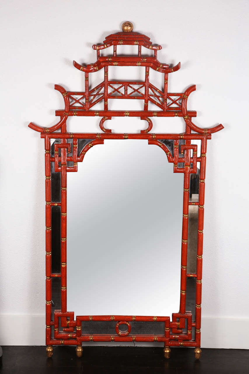 Chinese Chippendale style mirror, in the shape of a pagoda, with gilt accents on a red faux bamboo frame. Center mirror flanked by mirror panels.