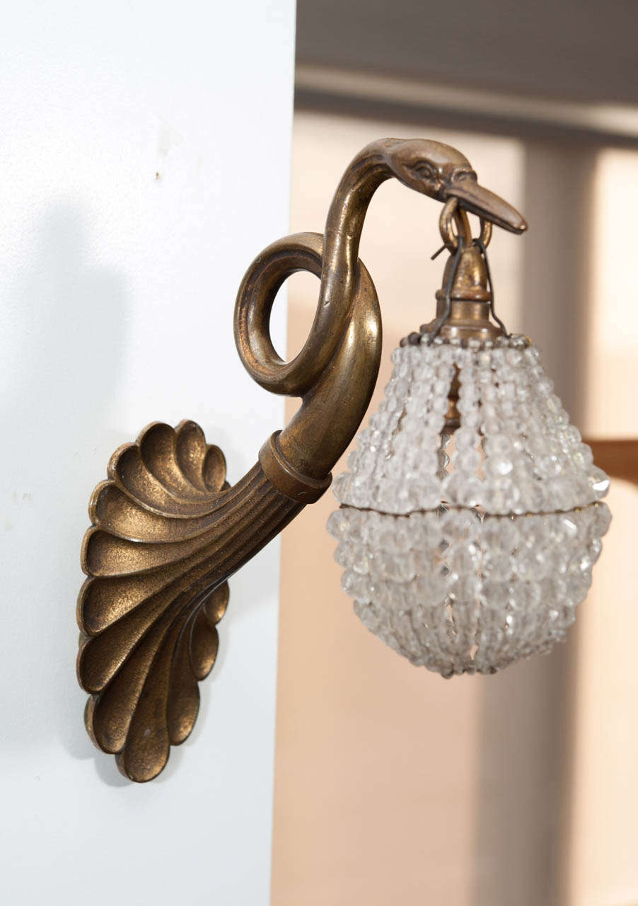 Empire revival bronze and crystal wall sconces, swan shaped, holding crystal beads lantern.