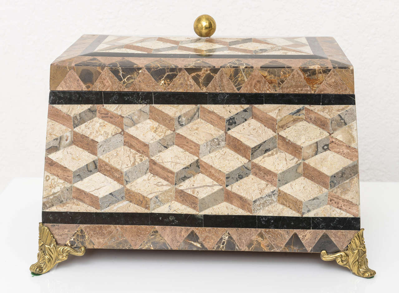 This stylish tessellated marble and brass box is very much in the style of pieces created by Maitland Smith and dates to the 1980s.  

Please feel free to contact us directly for a shipping quote or any additional information by clicking 