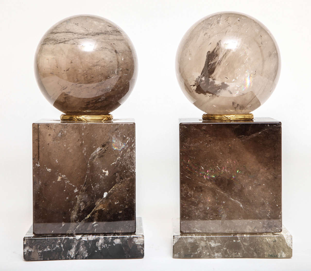 Pair of French smokey rock crystal orbs or spheres on plinths with gilt bronze, 20th century.