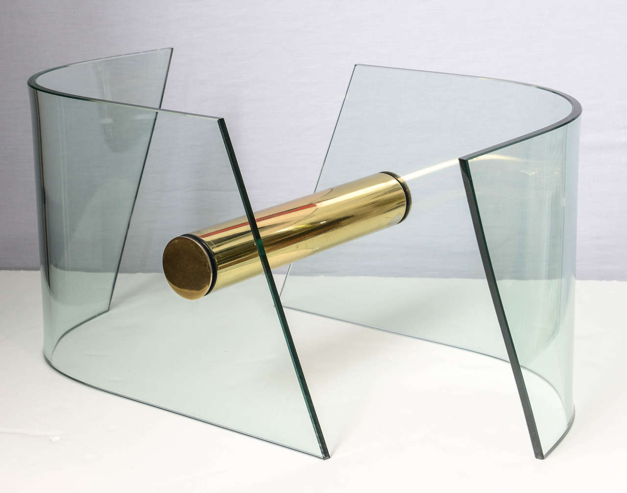 Bring back the 1970s in your living room with the perfectly elegant lines of this very unique coffee table base.  Two thick, curved, rhomboid glass pieces are held together with a stout and shiny brass cylinder.  This base strikes the perfect