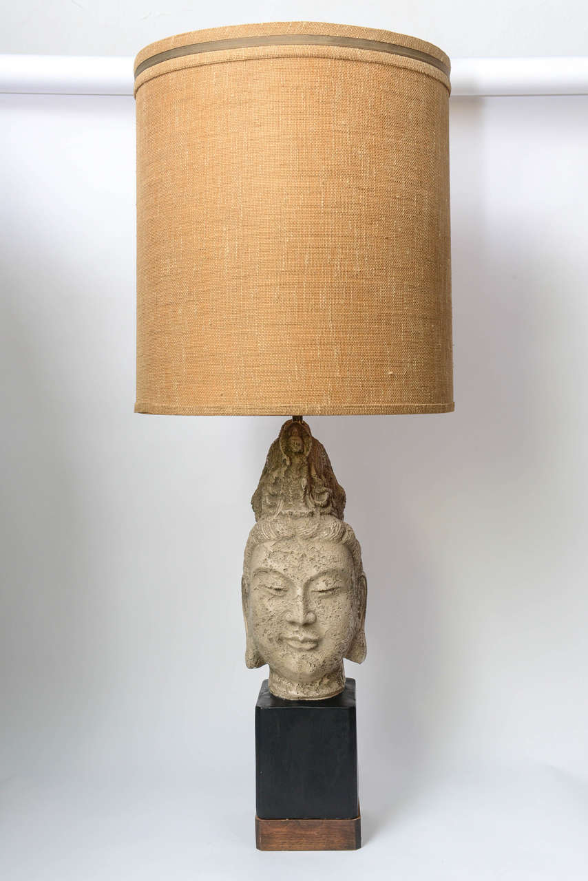 This iconic James Mont Buddha Table Lamp and original coarse-weave linen shade are in a beautiful vintage condition and working perfectly. The piece is made of cast plaster. The base is in walnut. 
Measurements:
- Lamp only: Height 28in. x Width
