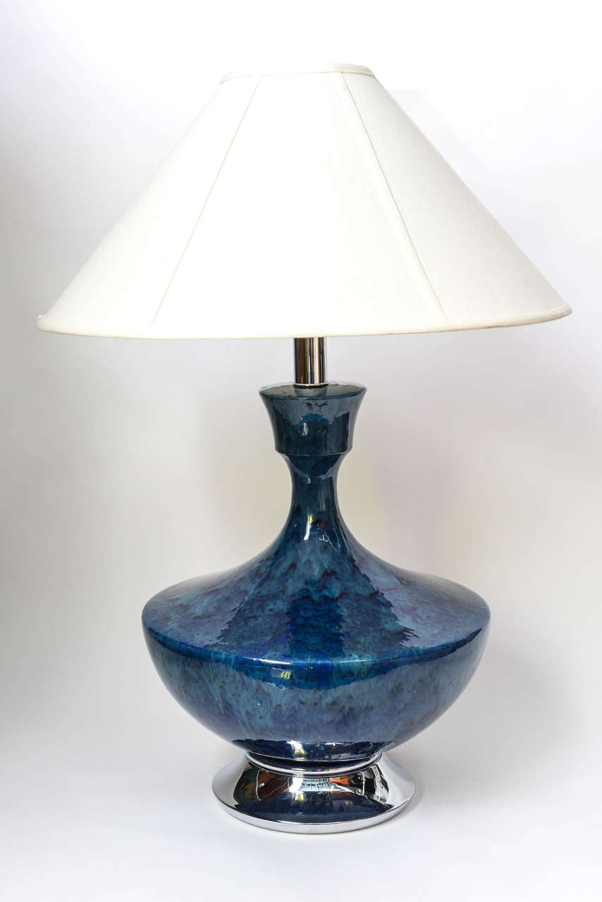 Give your table a touch of Mad Men with this beautiful mid-century lamp.  Dramatic urn style lines converge with glossy mottled vibrant blues and teals drip glaze colors to create a singular beauty.  Perfectly retro yet appropriate among modern