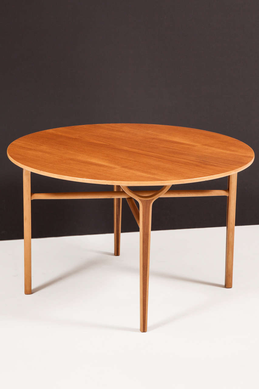 Danish teak and walnut circular table raised on four square tapered legs headed with half-round supports, joined by a circular X-form stretcher.

Designed by Peter Hvidt & Orla Molgaard-Nielsen, circa 1950