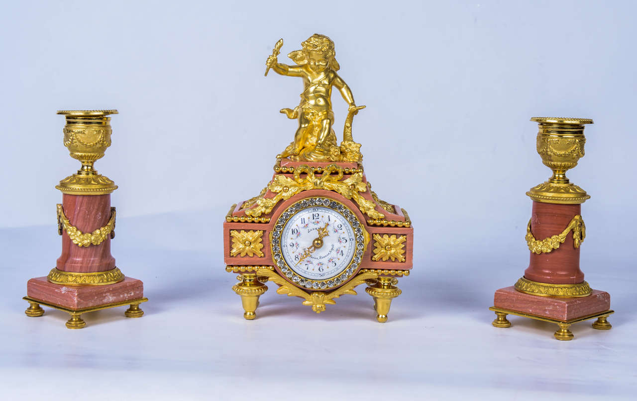 1 box with 3 jewellery pieces, 
- 1 little précious clock
- 2 candelsticks
red marble,,gilded bronze and strass.