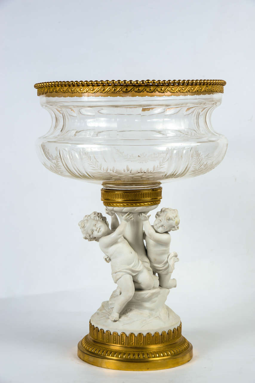 center of table,  crystal cup holded by biquit putti, resting on a gilded  bronze base.