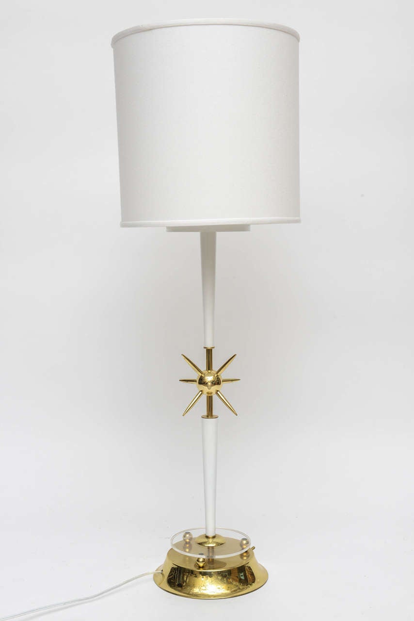 Newly lacquered in a brilliant white hi-gloss, enameled finish, with a tapered neck base. Newly plated and polished brass details. Brass base, atomic symbol center, end caps, neck stem and any brass joinery. Brass round, flared base has three finial