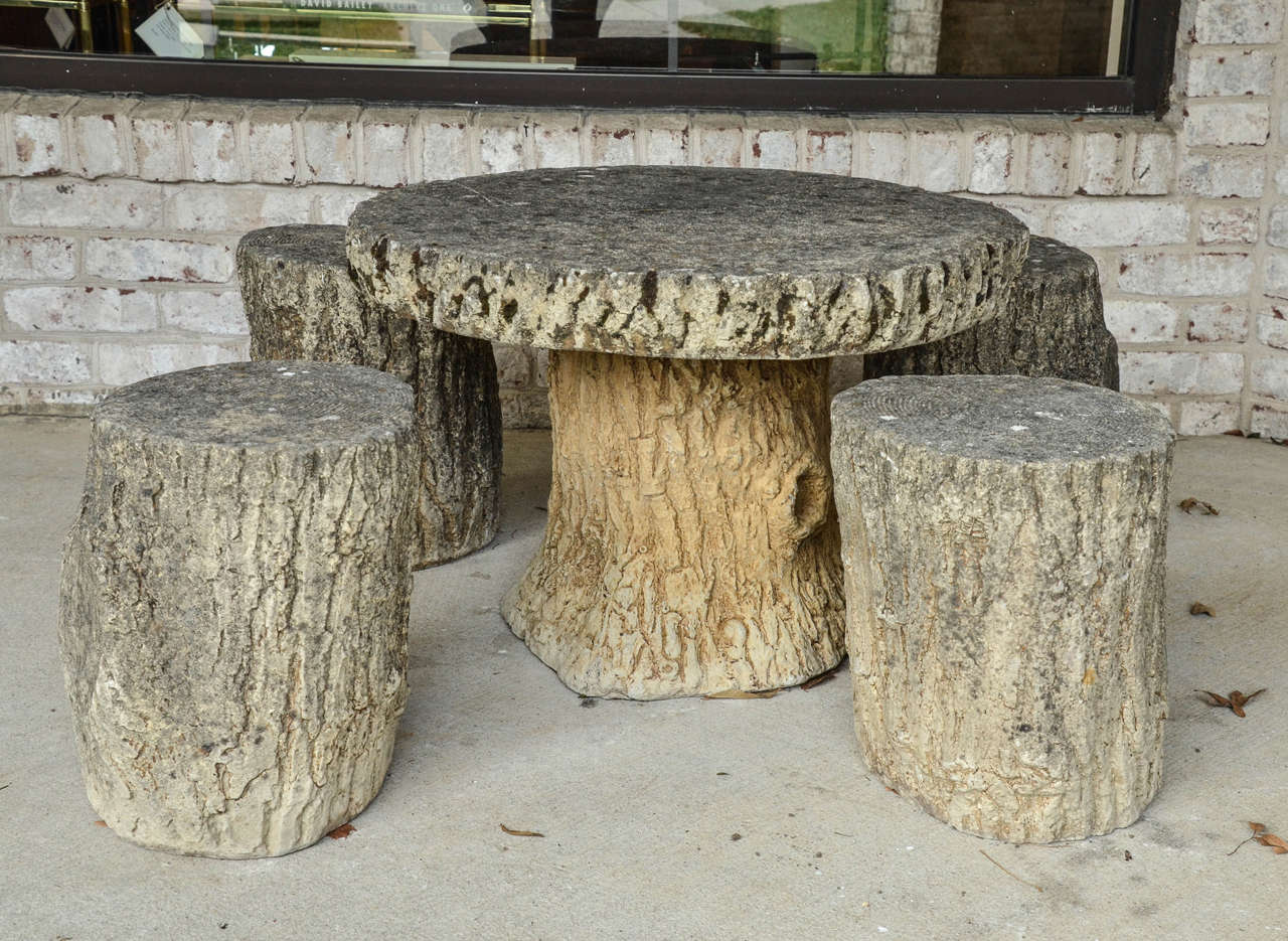 A nicely weathered fois bois concrete table and four matching stools. Measurements listed are for table. Stool measurements are 12