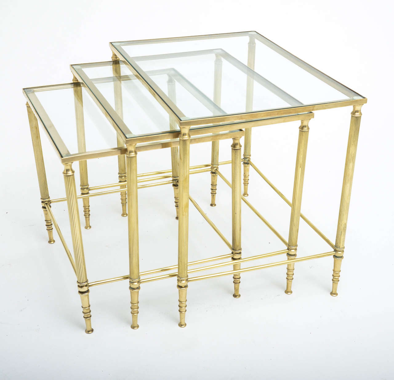 A 1950s, French, Baguès-style nest of three tables with reeded brass legs. Dimensions listed are for largest table.