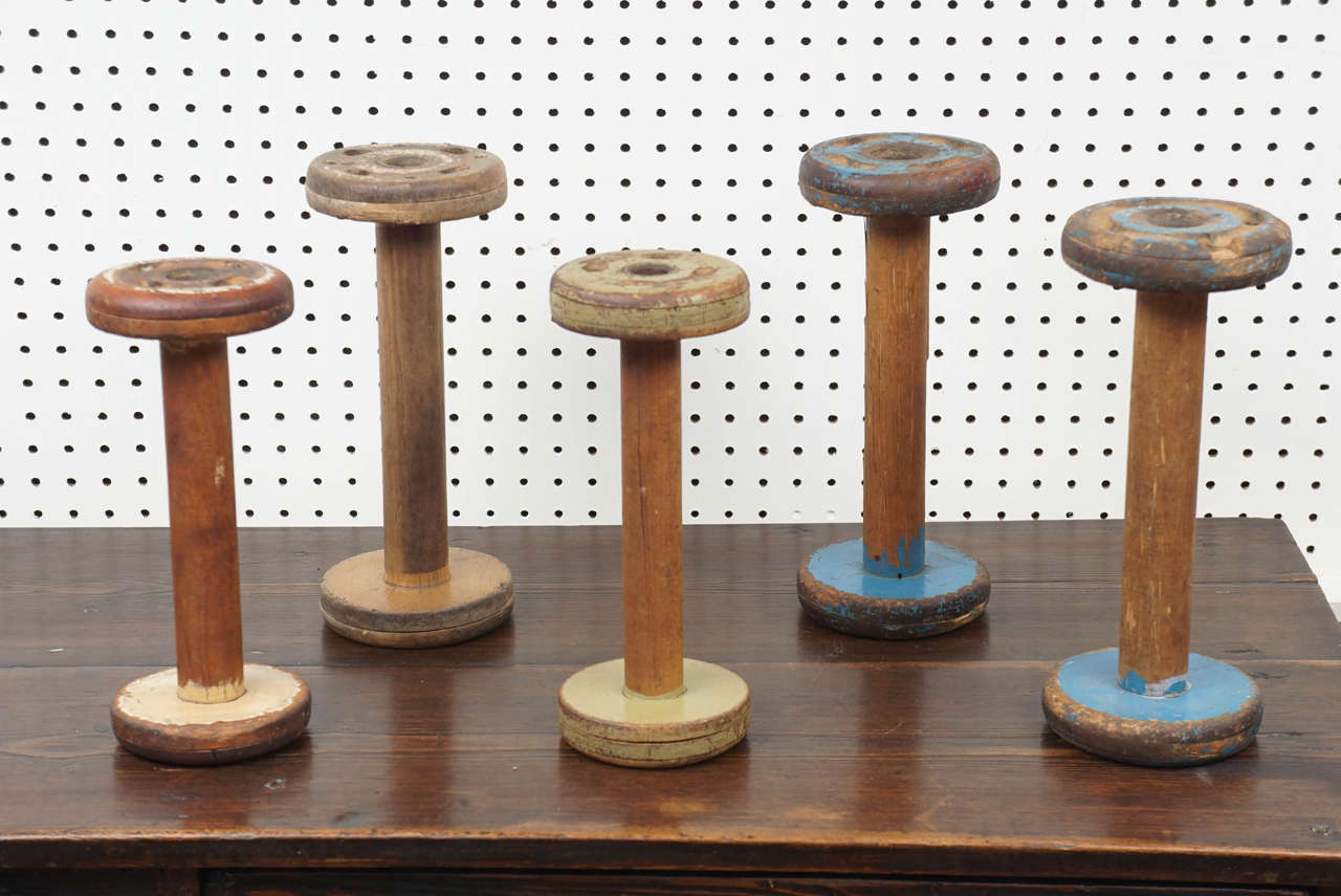 These spools of thread are from the 1920s and come in multiple colors. This collection can work anywhere in your home. We have a set on our coffee table with wooden balls on top of each spool. It's a Folk Art piece that will add some uniqueness to