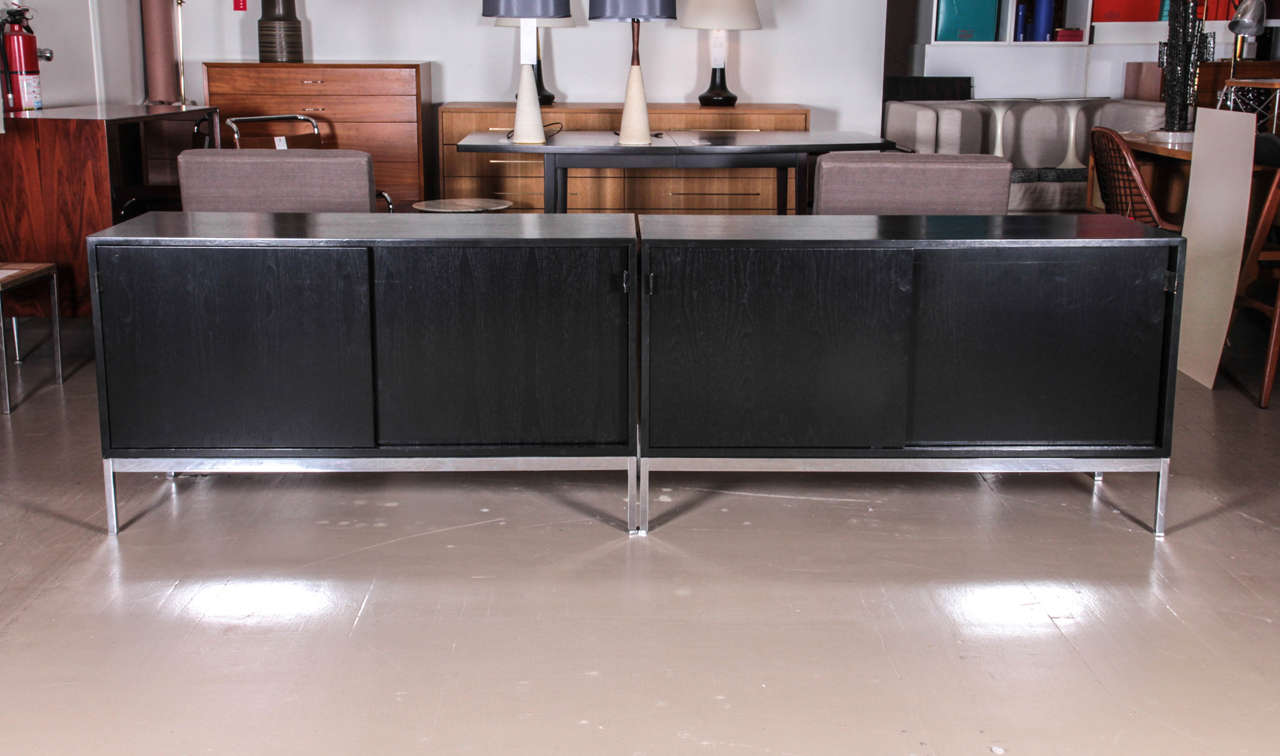 Pair of 1950s ebonized walnut sideboards with leather tabs and chrome frames by Florence Knoll.