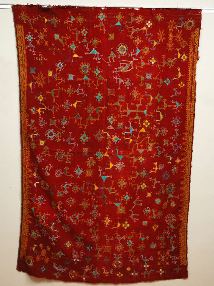 Loosely woven red wool blanket with pattern darning wool embroidery all over and as side borders.