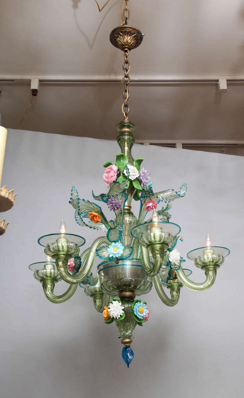 A six light Italian Murano glass chandelier. The handblown dish issuing S-shaped candle arms and branches and leaves, all with polychrome decoration and contrasting green edges.