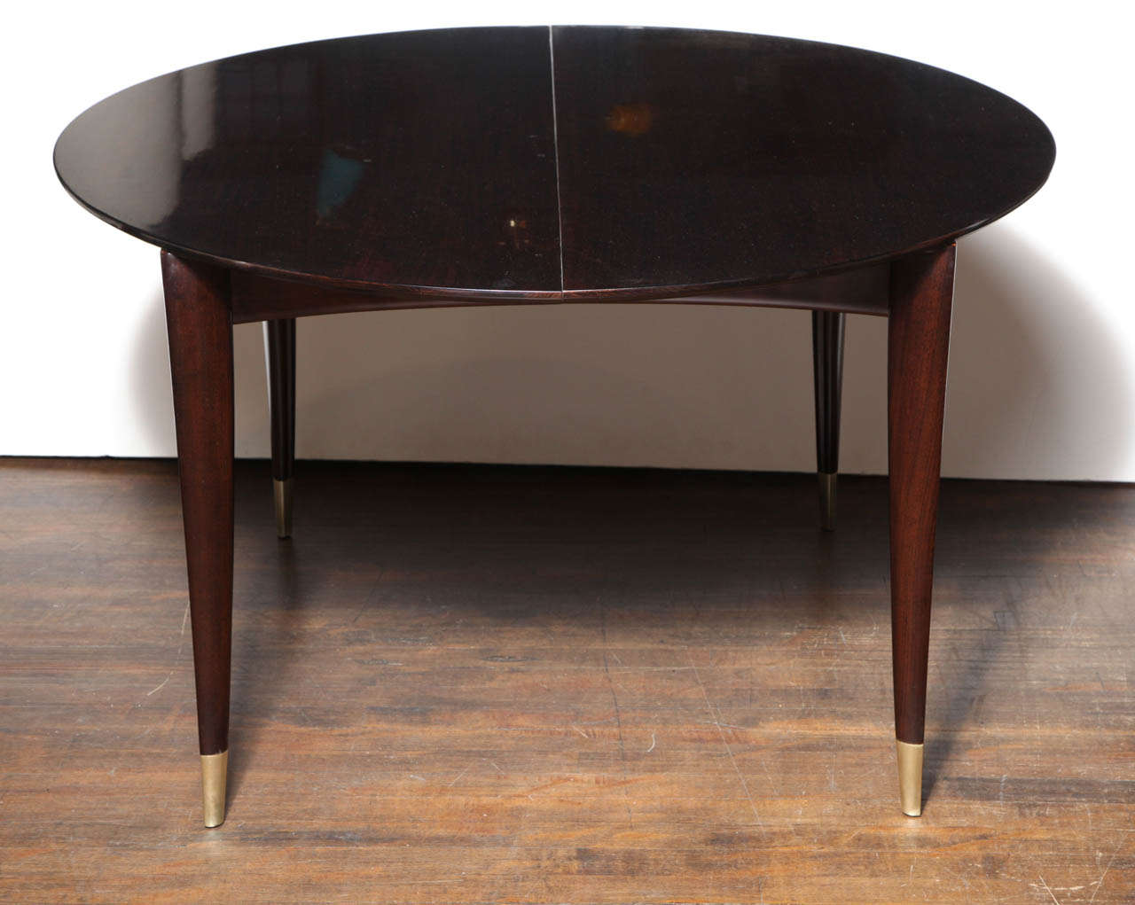 Boldly figured mahogany top with elegant tapering legs and 
brass sabots. This table comes with 4 x 14