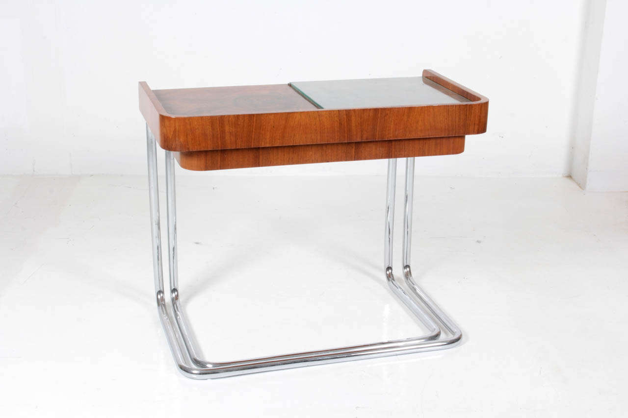 Bauhaus Germany (1919-1933).
Gebrüder Thonet, Vienna.

Nesting tables c. 1930.

Tubular chrome base with exotic wood and burl, glass inset half tops.

For more information see: Deutsche Stahlrohr Möbel, Alexander von Vegesack (München: