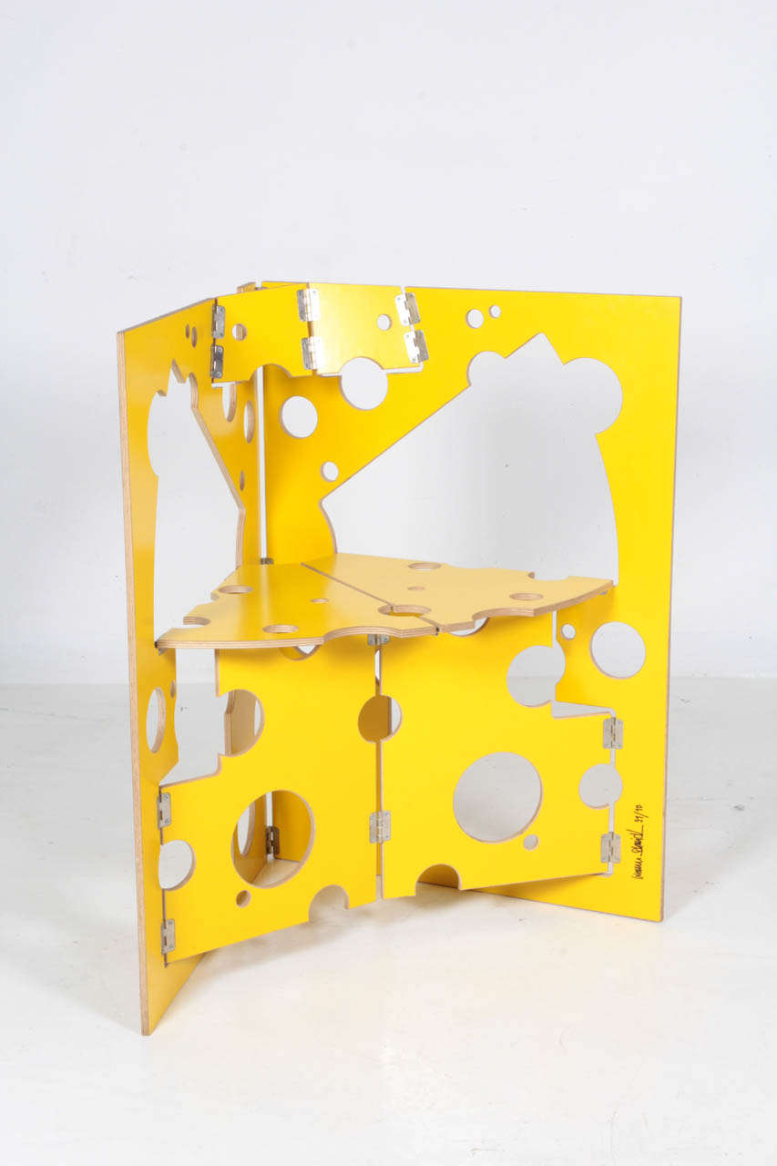 WERNER SCHMIDT  (b. 1953)  Suisse
  
Chaise fromage suisse  1991

Contreplaqué laminé jaune, charnières. 

Signé :  WERNER SCHMIDT (lettres majuscules), 91/10

Pour la table pliante de Schmidt, voir l'illustration : Aluminum by Design, Sarah